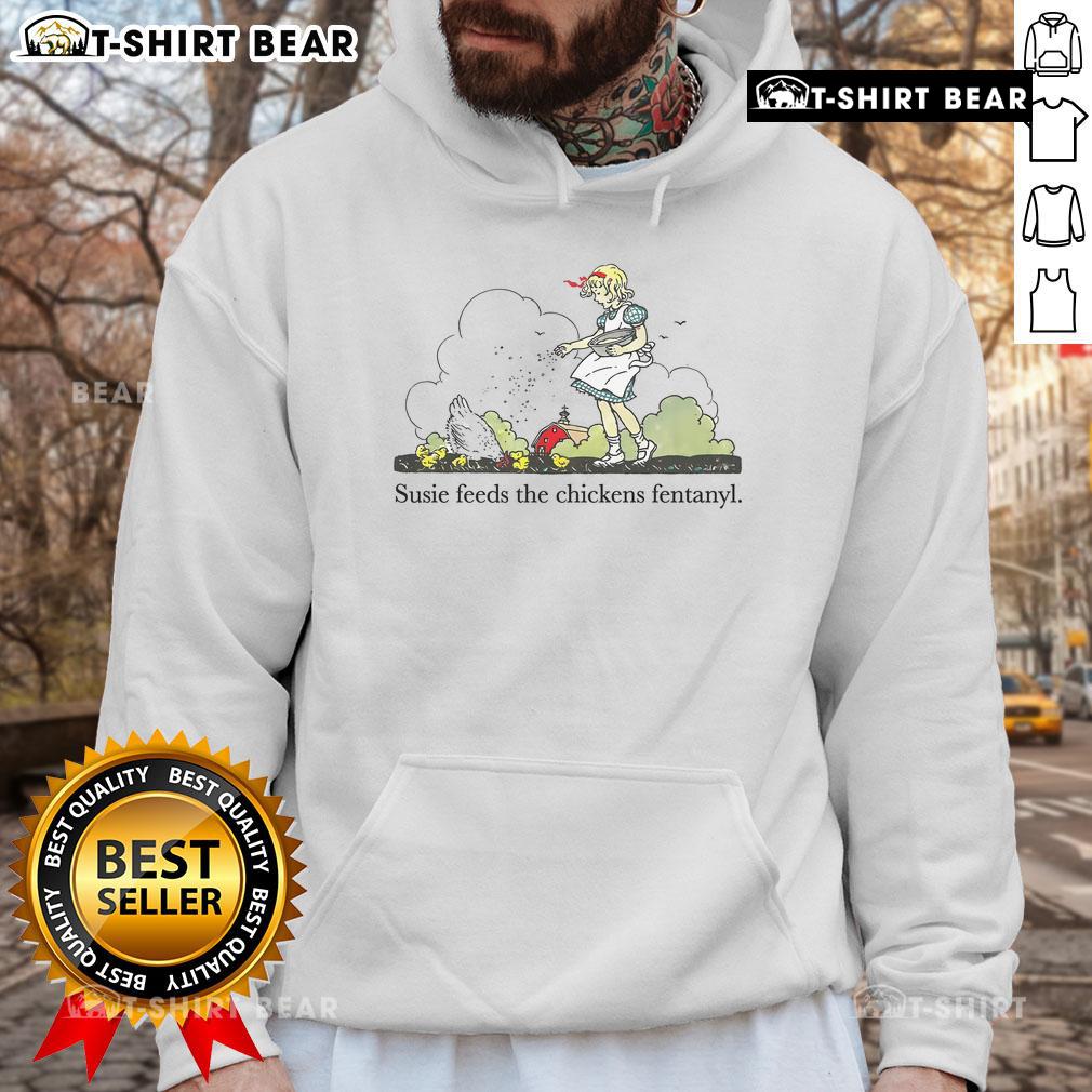 Pretty Susie feeds a chicken while wearing a Fentanyl hoodie, showcasing a unique streetwear style in a playful setting.