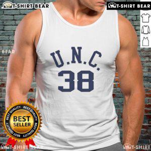 Alt Text: Bill Belichick wearing a vintage tank top featuring his dad's UNC logo at a football event, showcasing his unique style.