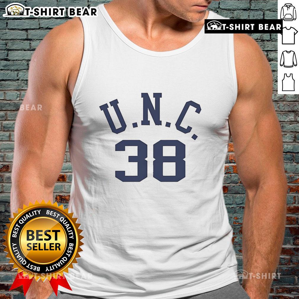 Alt Text: Bill Belichick wearing a vintage tank top featuring his dad's UNC logo at a football event, showcasing his unique style.