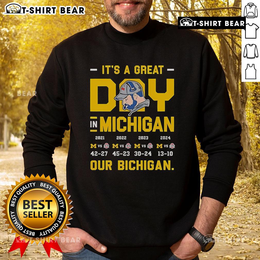 Person wearing a 'Bichigan' sweatshirt outdoors, enjoying a sunny day in Michigan, showcasing local pride and style.