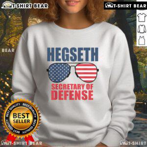 Top Hegseth Secretary of Defense wearing sunglasses in MAGA sweatshirt, showcasing Trump's pick for defense role.