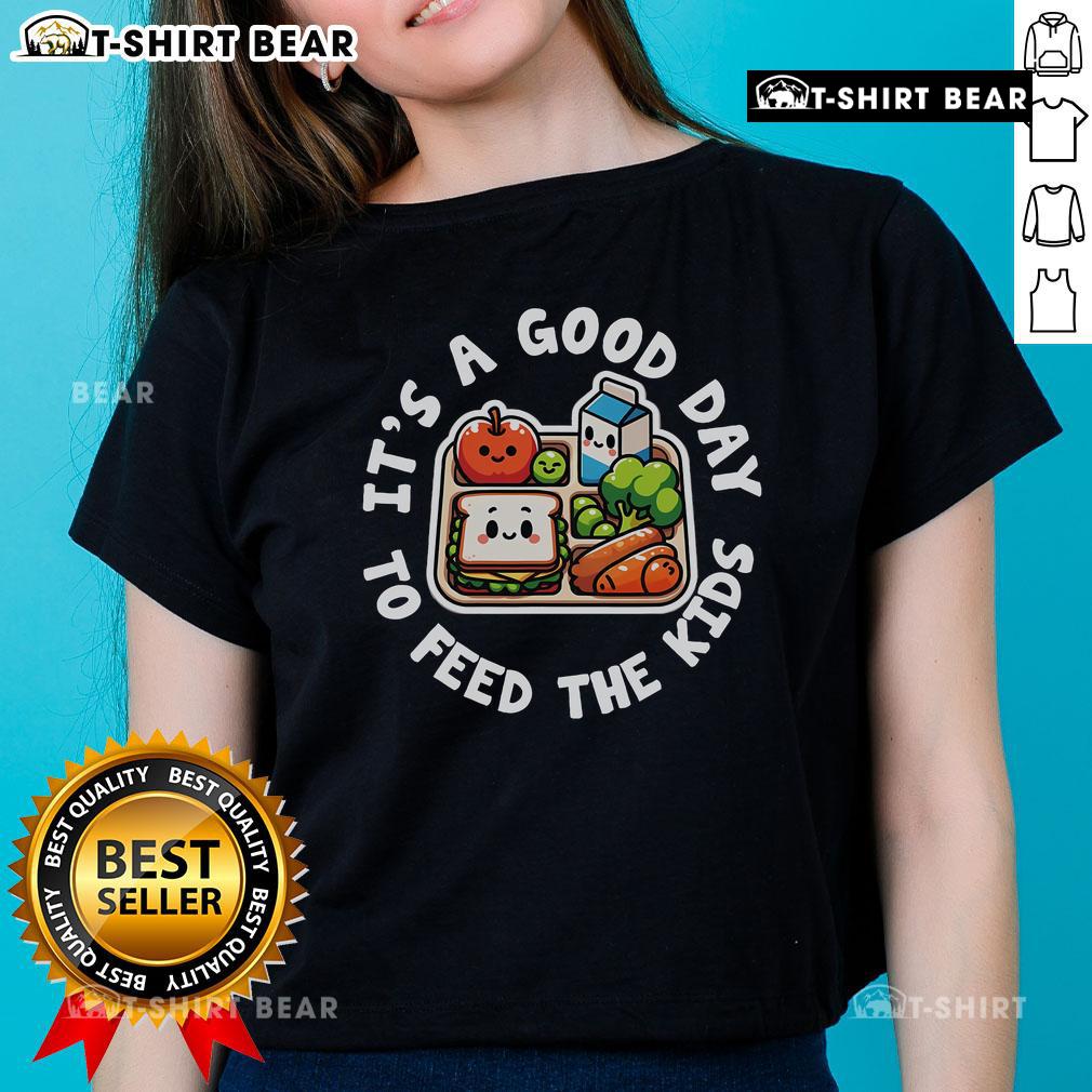 School cafeteria staff worker wearing a 'Good Day to Feed the Kids' tee, celebrating lunch lady appreciation.