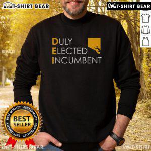 Alt Text: Official M. Scott wearing a Dei Duly Elected Incumbent sweatshirt, showcasing support for local governance.