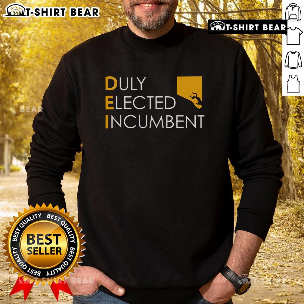 Alt Text: Official M. Scott wearing a Dei Duly Elected Incumbent sweatshirt, showcasing support for local governance.