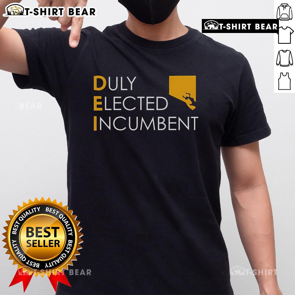 Alt Text: Official M Scott proudly wearing the Dei Duly Elected Incumbent T-Shirt, showcasing his commitment to public service.