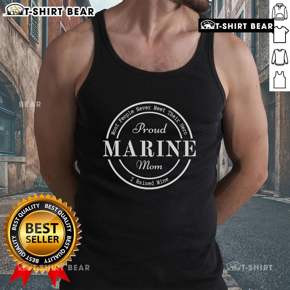 Marine mom proudly wearing tank top with 'I Raised Mine' slogan, celebrating her hero son in the military.