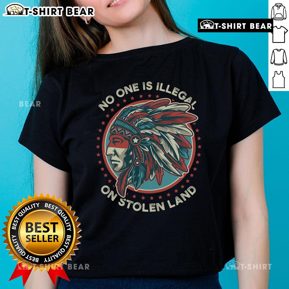 Women wearing 'No One Is Illegal On Stolen Land' tees at an anti-Trump protest, promoting immigration rights and justice.