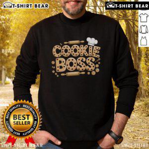 Girl wearing a sweatshirt with 'Top Scout Cookie Boss', messy bun, and sunglasses, enjoying a sunny day outdoors.