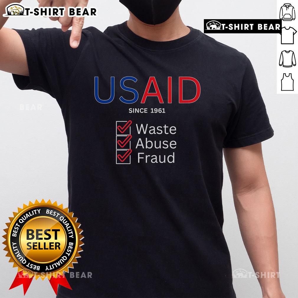Top USAID Waste Abuse Fraud Checked Since 1961 T-Shirt design featuring bold text and a stylish graphic.