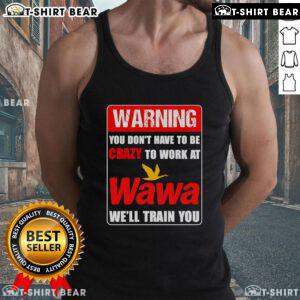Person wearing a 'You Don't Have to Be Crazy to Work at Wawa' tank top, showcasing fun Wawa work culture and training.