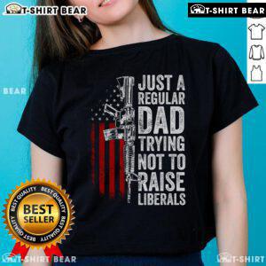 Top Just A Regular Dad Trying Not To Raise Liberals Ladies Tee featuring humorous text on a casual shirt design.