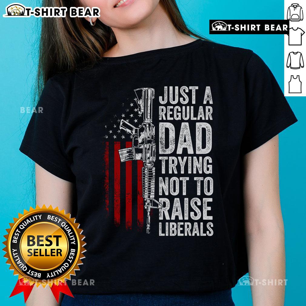 Top Just A Regular Dad Trying Not To Raise Liberals Ladies Tee featuring humorous text on a casual shirt design.