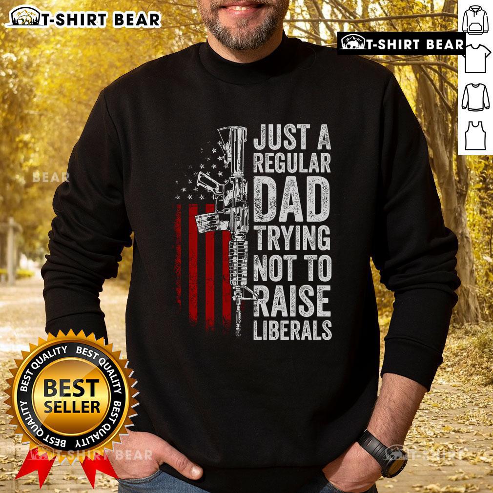 Top Just A Regular Dad Trying Not To Raise Liberals Sweatshirt featuring humorous text design for dads.