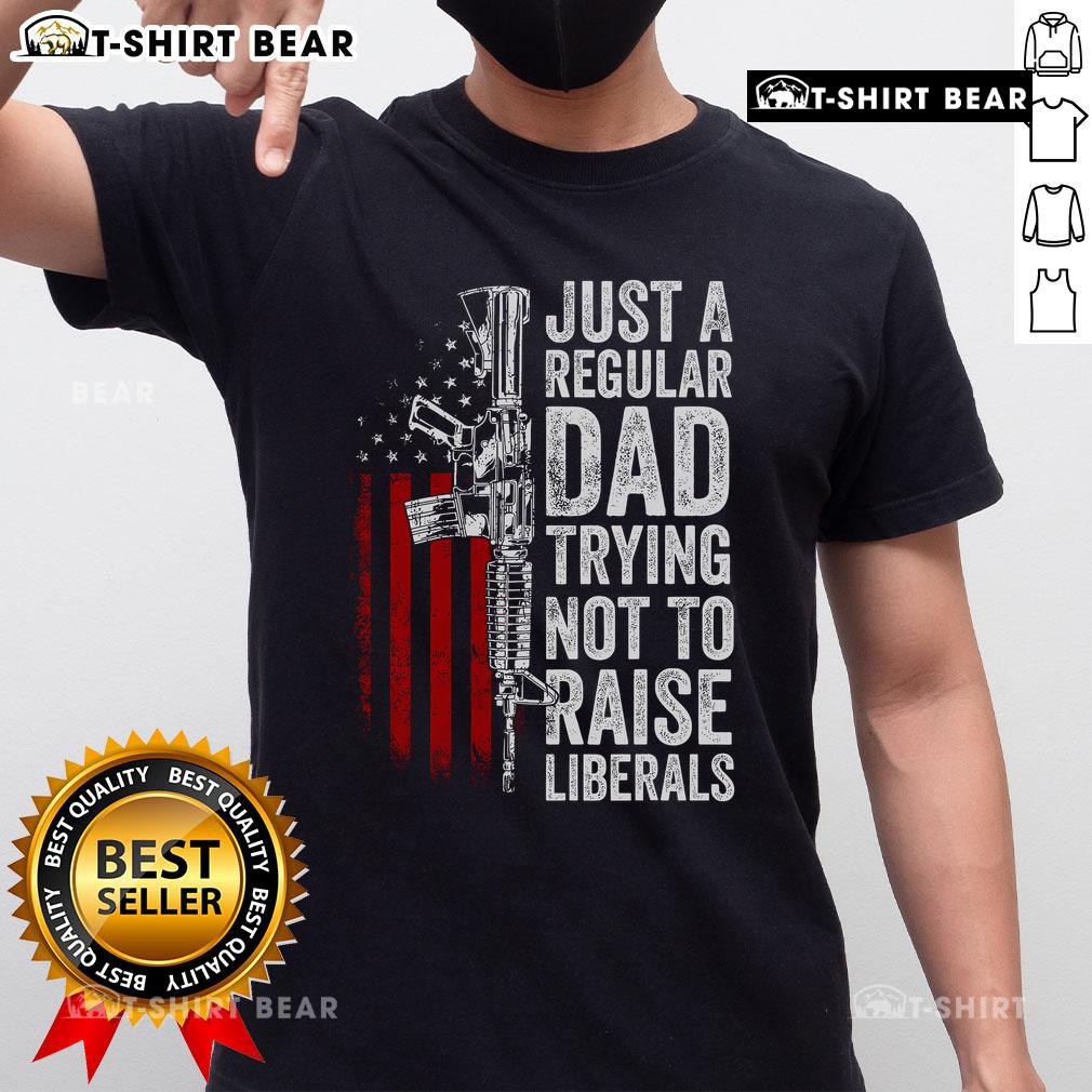 Top Just A Regular Dad Trying Not To Raise Liberals T-Shirt featuring bold text on a casual tee for dads with a humorous twist.