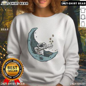 Funny astronaut mining on the moon for space coins on a cozy sweatshirt, perfect for space enthusiasts.