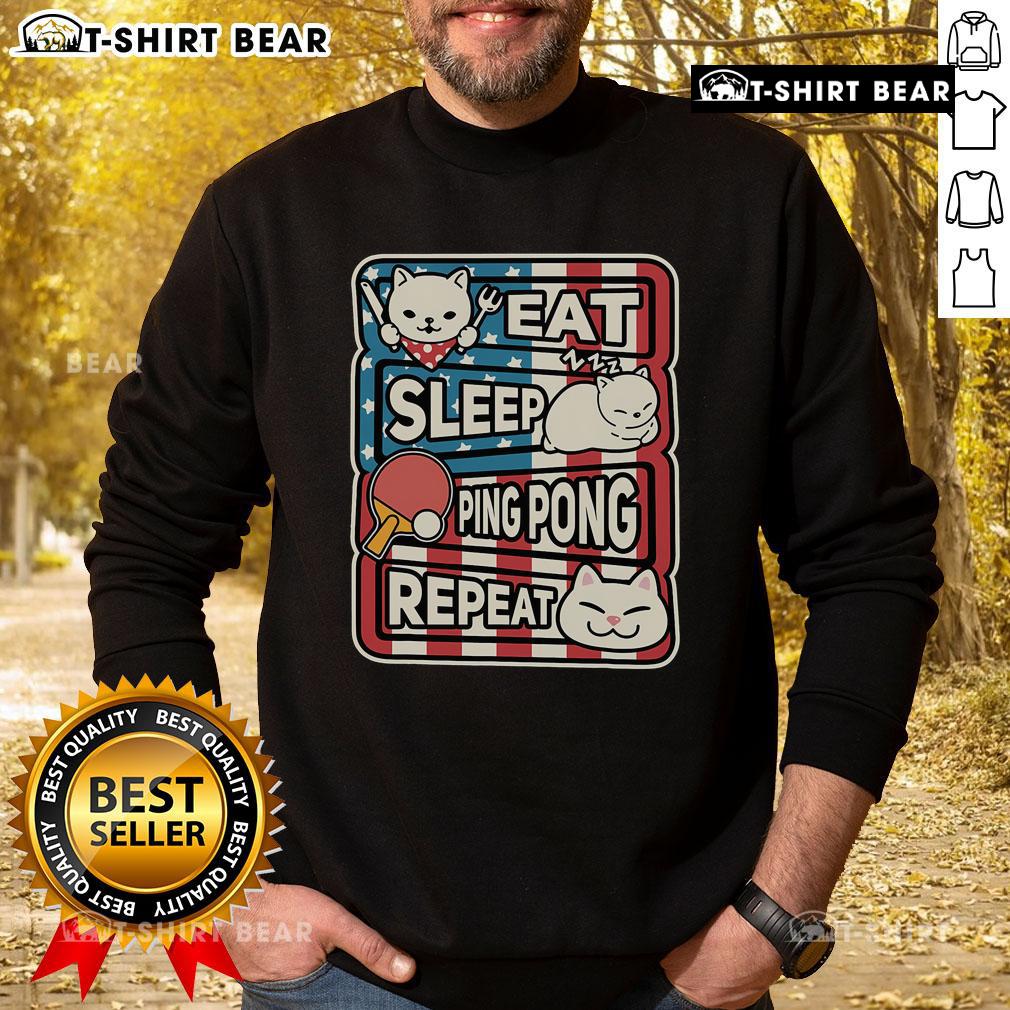 Cute cat in a patriotic sweatshirt playing ping pong, representing the eat, sleep, table tennis, repeat lifestyle.
