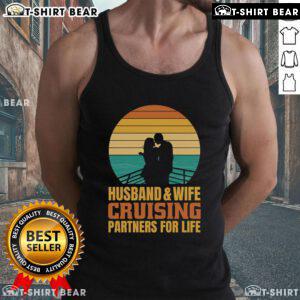 Couple wearing 'Top Husband and Wife Cruising Partners for Life' vintage tank tops against a beautiful sunset backdrop.