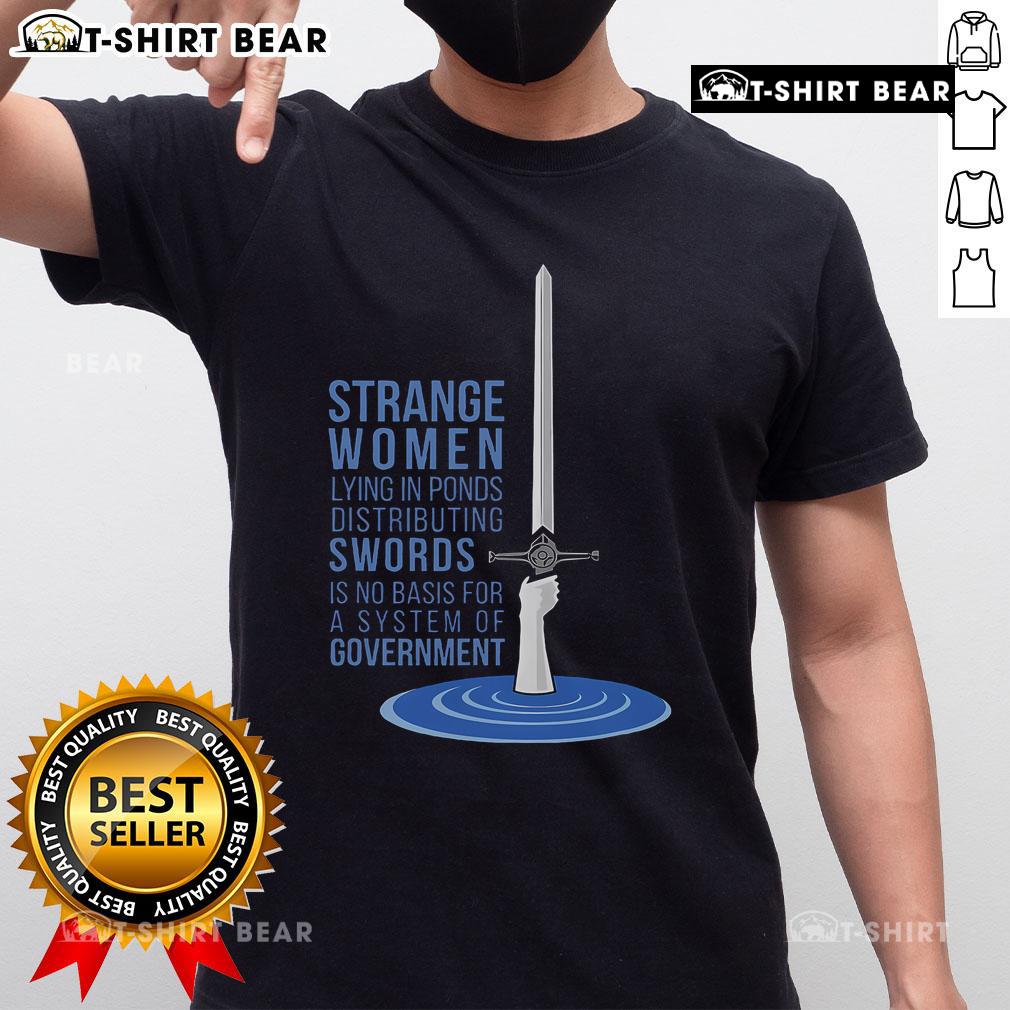 Top Strange Women Lying In Ponds Distributing Swords T-Shirt featuring whimsical art and humorous political commentary.