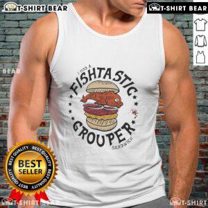 Fan wearing a 'Flavortown' tank top enjoying a grouper sandwich at a Tampa Bay Buccaneers game.