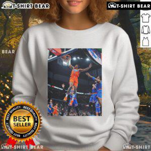 Alt Text: Jalen Williams soaring for a score in a black Oklahoma sweatshirt, showcasing athleticism and team spirit.