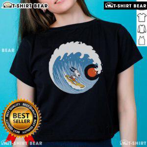Pretty Snoopy Big Wave Adventure ladies tee featuring a colorful design of Snoopy surfing on a big wave.