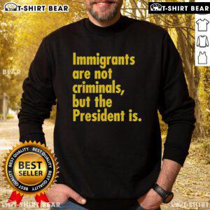 Top Immigrants Are Not Criminals But The President Is sweatshirt design featuring a bold, colorful slogan on a cozy fabric.