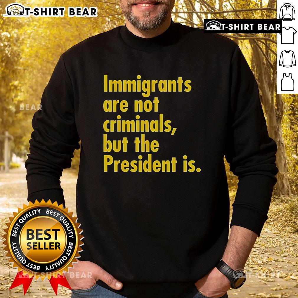 Top Immigrants Are Not Criminals But The President Is sweatshirt design featuring a bold, colorful slogan on a cozy fabric.