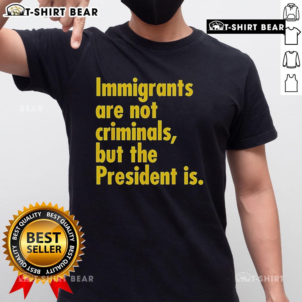 Top Immigrants Are Not Criminals But The President Is T-Shirt featuring bold text, promoting immigrant rights and awareness.