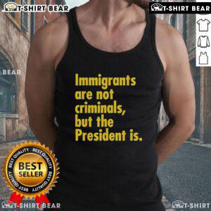 Person wearing 'Top Immigrants Are Not Criminals But The President Is' tank top, promoting immigrant rights and awareness.
