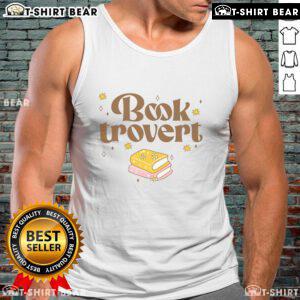 Funny book lover wearing a 'Pretty Booktrovert' tank top while reading a book in a cozy setting.