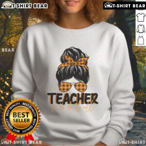Pretty teacher in a messy bun wearing the 'We Do It All' sweatshirt, showcasing stylish and comfortable teaching apparel.