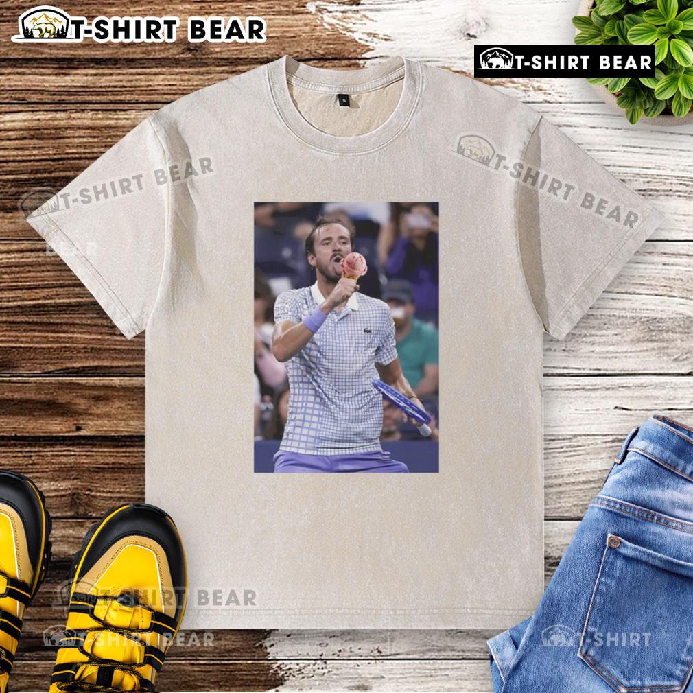 Daniil Medvedev enjoying ice cream on the field at the US Open, wearing a washed t-shirt and smiling.