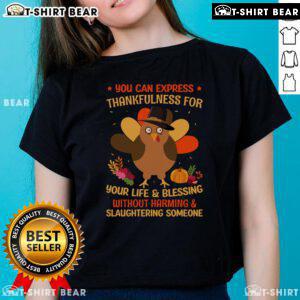Turquoise ladies' tee with 'Thankfulness Without Harming' graphic, promoting a compassionate Thanksgiving message.