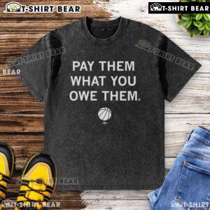Top Basketball Pay Them What You Owe Them washed t-shirt displayed on a hanger, featuring a stylish design for fans.