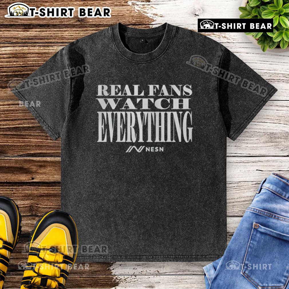 Top Real Fans Watch Everything washed t-shirt displayed on a hanger, showcasing its stylish design and soft fabric.