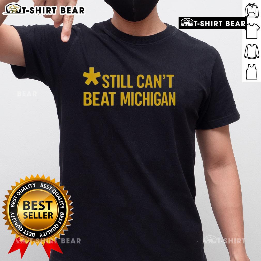 Top Still Can't Beat Michigan T-Shirt featuring bold graphics and a sporty design, perfect for Wolverines fans.