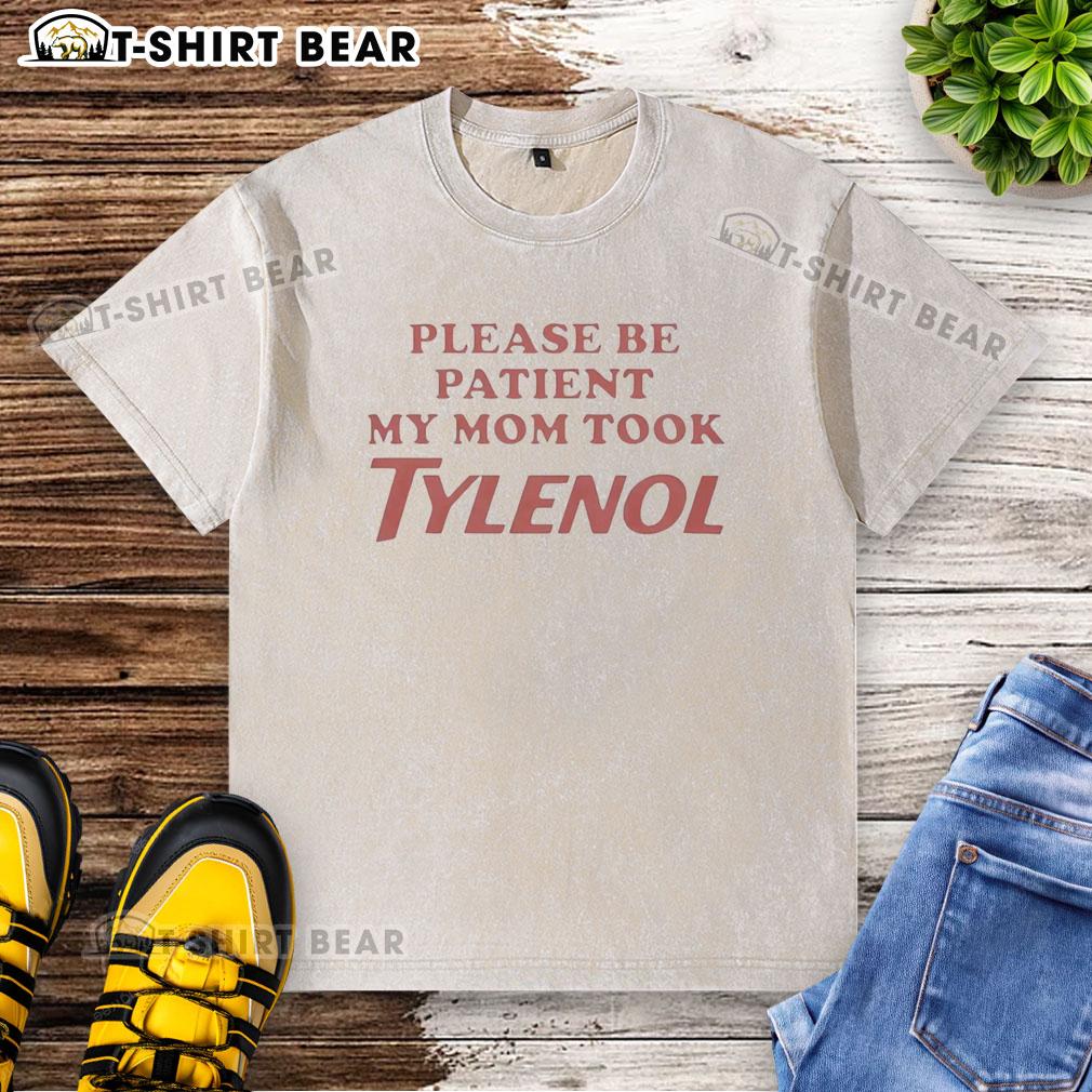 Top Please Be Patient My Mom Took Tylenol washed t-shirt displayed on a hanger, featuring humorous text design.