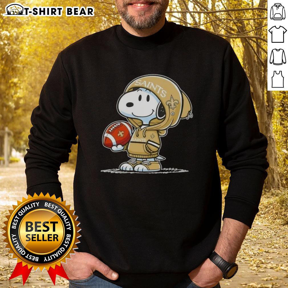 Alt Text: Snoopy in a hoodie supporting the New Orleans Saints, smiling at fans, featured on a stylish sweatshirt.
