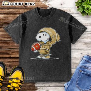 Alt Text: Snoopy in a hoodie, smiling at fans, showcasing the Official Peanuts New Orleans Saints washed t-shirt design.