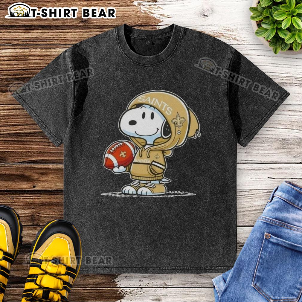 Alt Text: Snoopy in a hoodie, smiling at fans, showcasing the Official Peanuts New Orleans Saints washed t-shirt design.