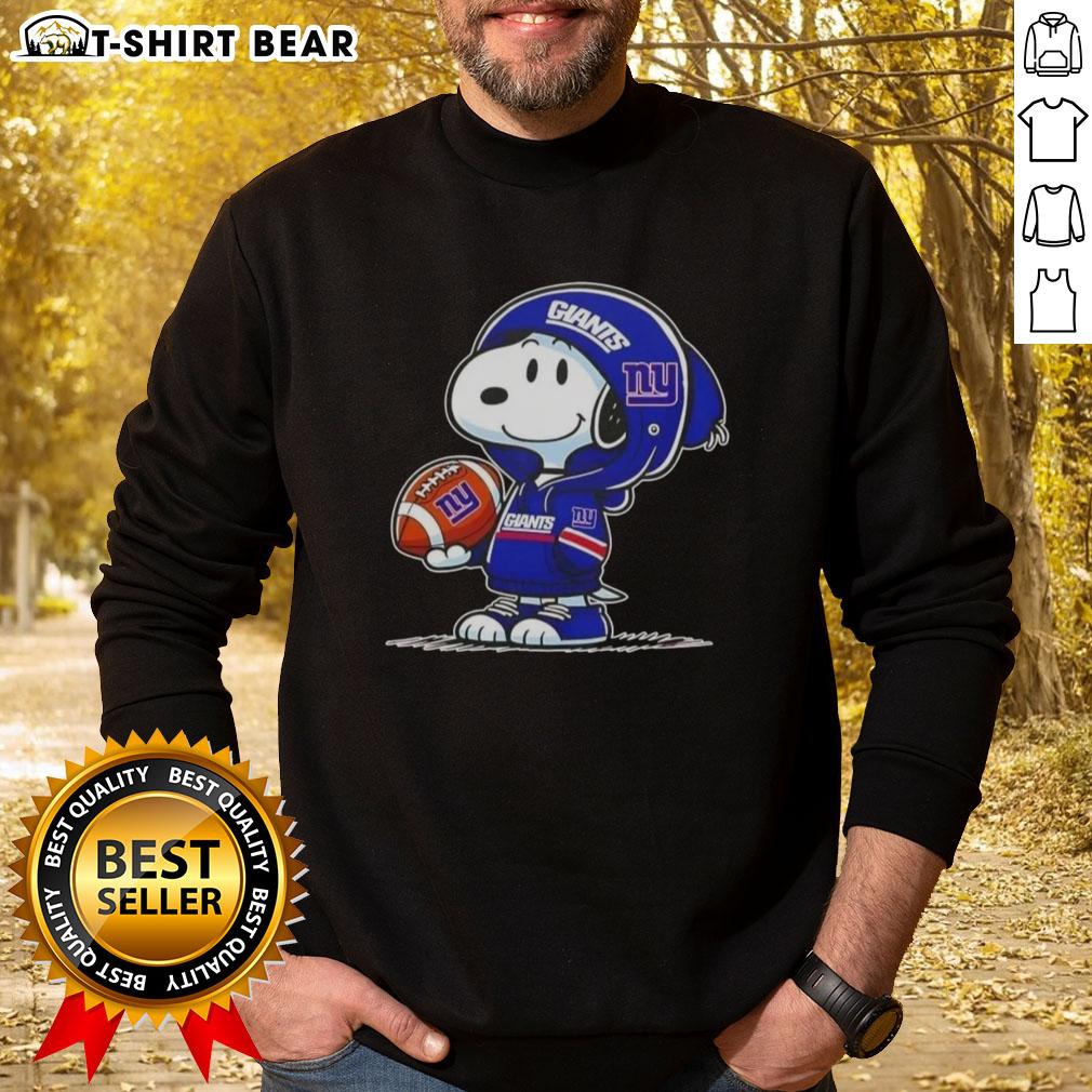 Snoopy in a New York Giants hoodie smiles at fans, showcasing the Official Peanuts sweatshirt design.