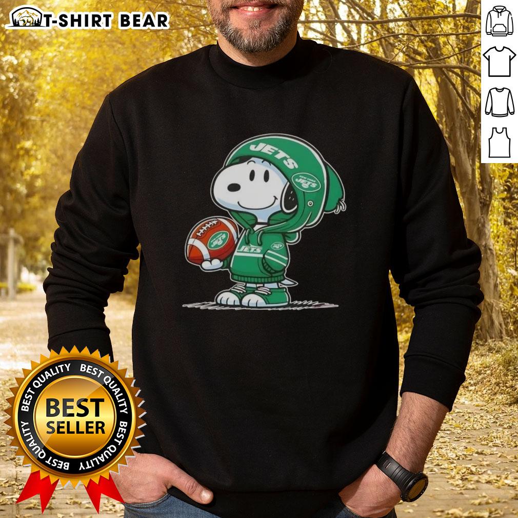 Alt Text: Snoopy in a New York Jets hoodie smiling at fans, showcasing the official Peanuts sweatshirt design.