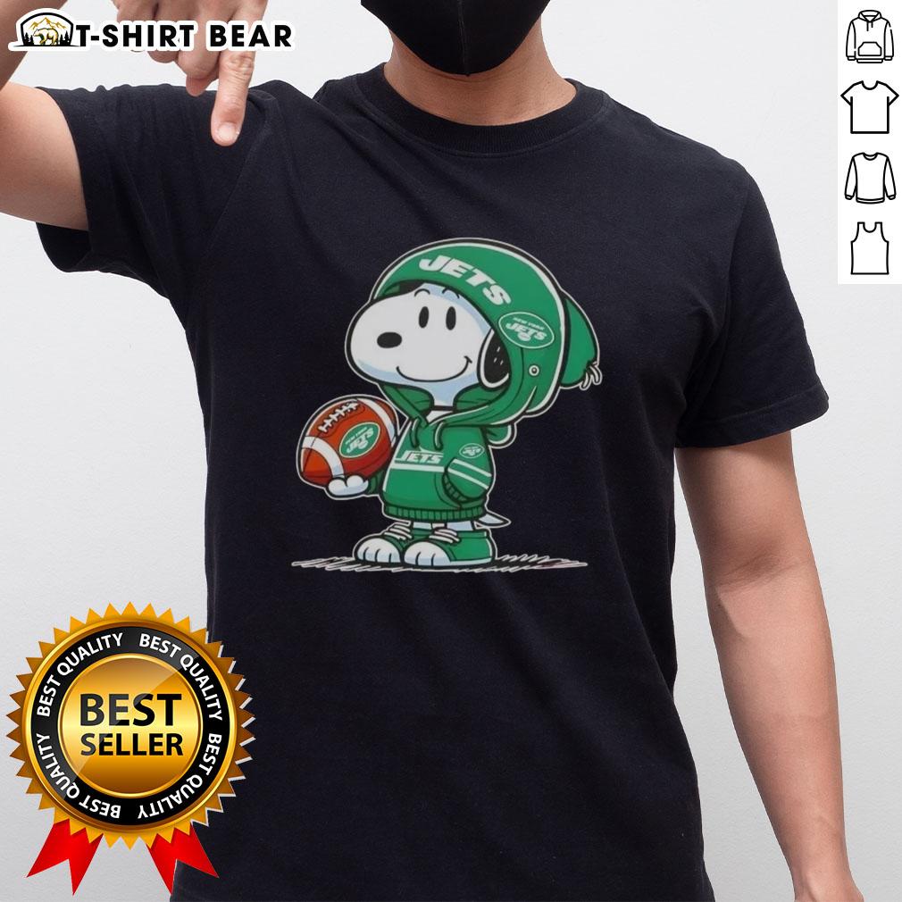 Alt Text: Snoopy wearing a New York Jets hoodie smiles at fans on a fun Peanuts-themed t-shirt design.