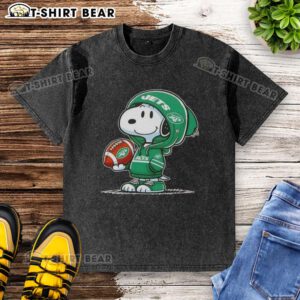 Alt Text: Snoopy in a New York Jets hoodie smiles at fans on a washed t-shirt, featuring the official Peanuts design.