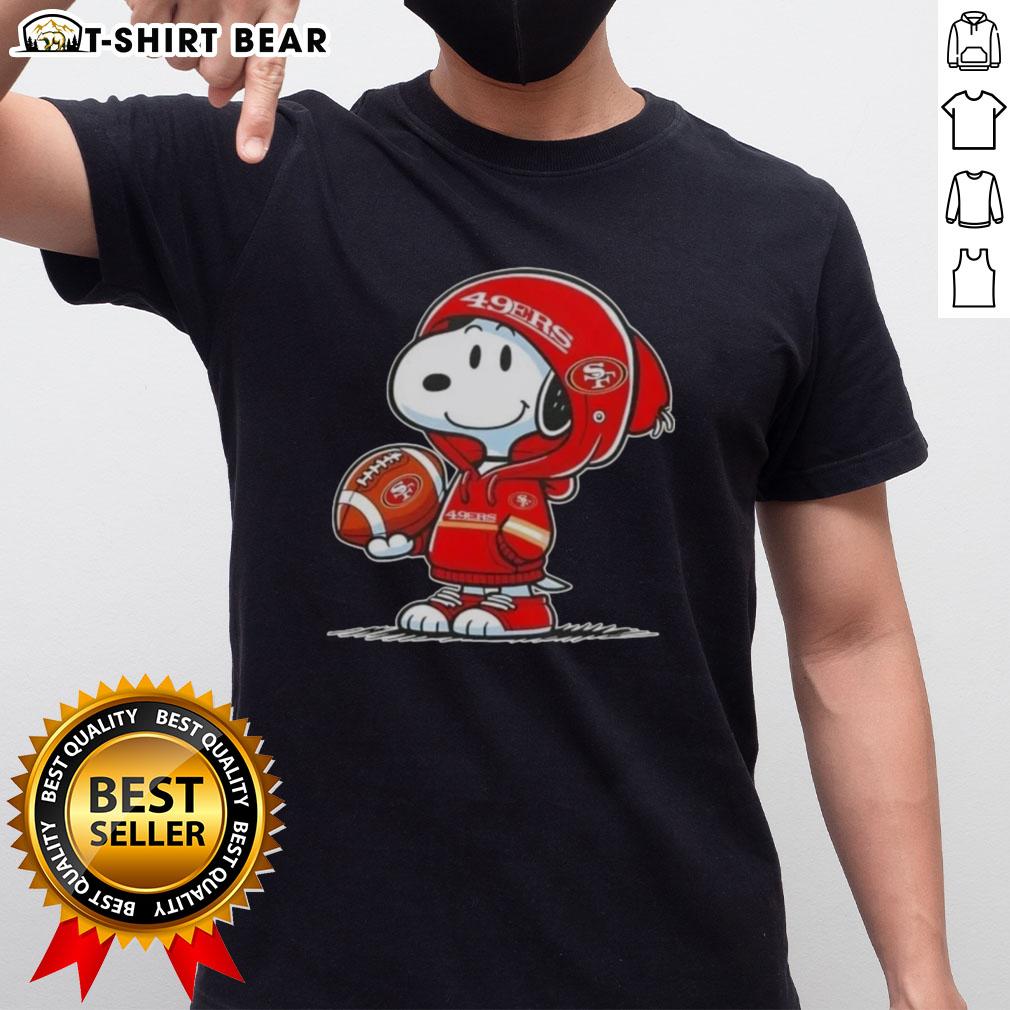 Alt Text: Snoopy in a hoodie supporting the San Francisco 49ers, smiling at fans on a vibrant T-shirt design.