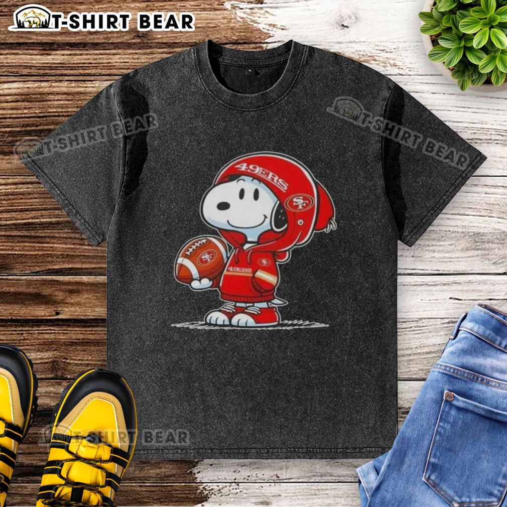 Snoopy wearing a San Francisco 49ers hoodie, smiling at fans on a washed t-shirt design, perfect for Peanuts fans.