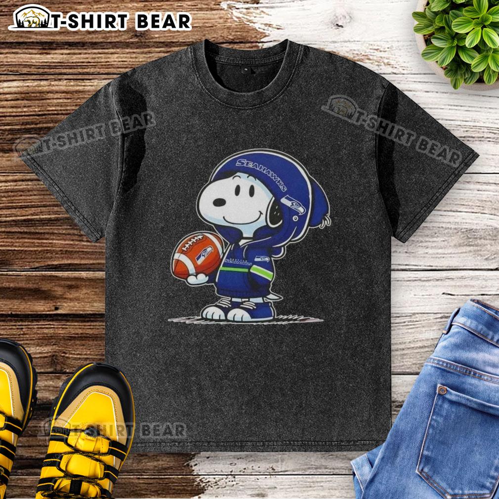 Snoopy in a Seattle Seahawks hoodie smiles at fans, featured on an Official Peanuts washed t-shirt.