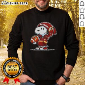 Alt Text: Snoopy in a Washington Commanders hoodie smiles at fans, showcasing the official Peanuts sweatshirt design.