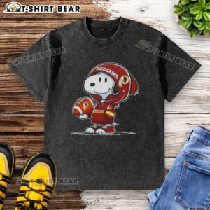 Alt Text: Snoopy in a Washington Commanders hoodie, smiling at fans, featured on a washed t-shirt design. Official Peanuts merchandise.