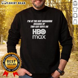 Man wearing 'Good I'm At The Boy Aquarium' sweatshirt, inspired by two gay guys on HBO Max, at a vibrant aquarium.